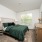 Bed with green bedding and large window
