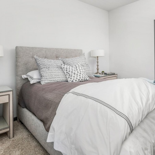 a bedroom with a bed and tables with a lamps